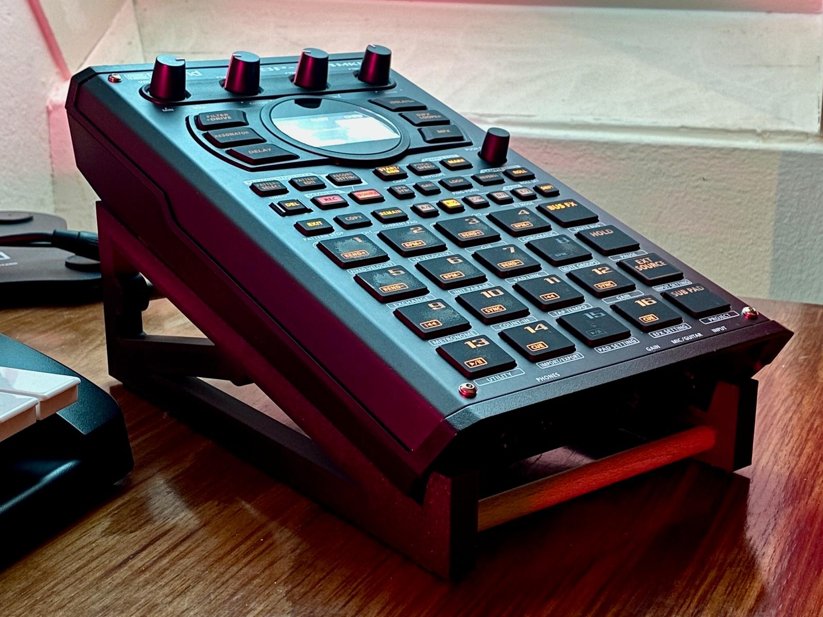 Roland SP-404MKII on its made-to-measure stand, tilted toward the player under red LED light